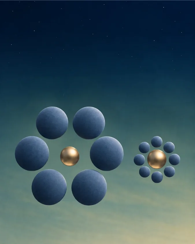 Two identical gold spheres, one ringed by large spheres and one by small spheres, so they look like different sizes