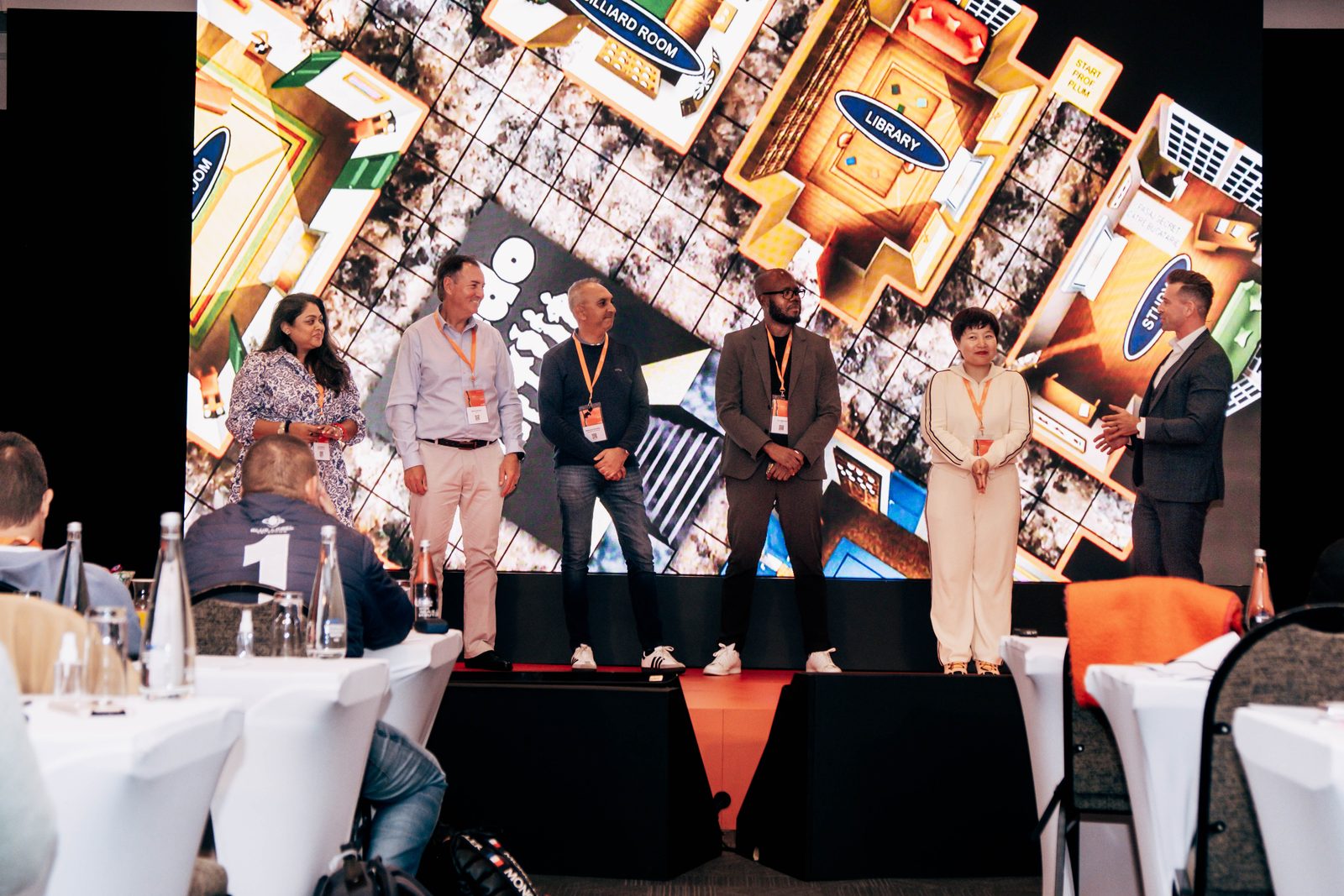 Gilan on stage with a group of volunteers